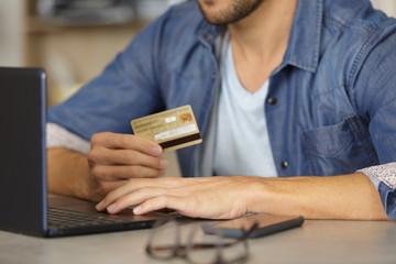 man paying with credit card on smart phone at home