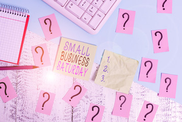 Text sign showing Small Business Saturday. Business photo text American shopping holiday held during the Saturday Writing tools, computer stuff and math book sheet on top of wooden table