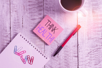 Text sign showing Think Health. Business photo showcasing state of complete physical mental and social well being Stationary placed next to a cup of black coffee above the wooden table