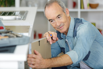 mature man assembling bed in new home