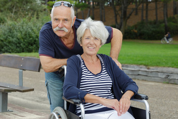Fototapeta na wymiar senior man and woman in wheelchair in park