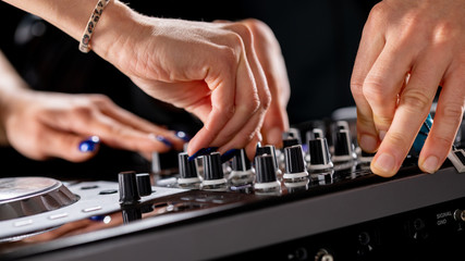 Fototapeta na wymiar male and female DJ hands on a DJ consolle