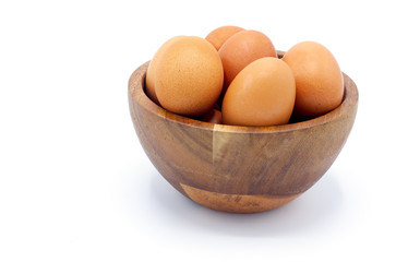 Fresh chicken eggs in a wooden bowl on a white background