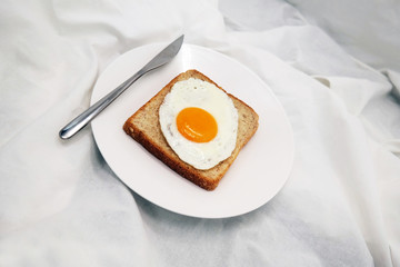 Cooked Egg On The Bread With Silver Knife On The White Dish
