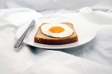 Cooked Egg On The Bread With Silver Knife On The White Dish