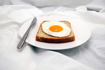 Cooked Egg On The Bread With Silver Knife On The White Dish