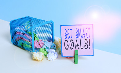 Text sign showing Set Smart Goals. Business photo text list to clarify your ideas focus efforts use time wisely Trash bin crumpled paper clothespin empty reminder office supplies tipped