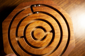 Wooden maze for the ball. Tool for coordination training. A spiral carved in a piece of wood. Wood texture. The combination of brown colors.