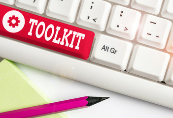 Word writing text Toolkit. Business photo showcasing set of tools kept in a bag or box and used for a particular purpose White pc keyboard with empty note paper above white background key copy space