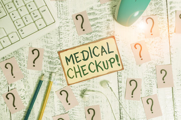 Handwriting text writing Medical Checkup. Conceptual photo thorough physical examination includes variety of tests Writing tools, computer stuff and scribbled paper on top of wooden table