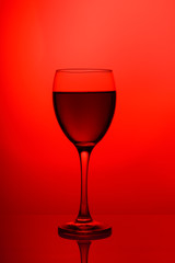 Wineglass with red wine close-up isolated on pink background