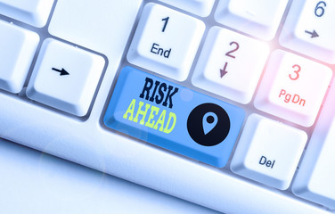 Conceptual hand writing showing Risk Ahead. Concept meaning A probability or threat of damage, injury, liability, loss White pc keyboard with note paper above the white background