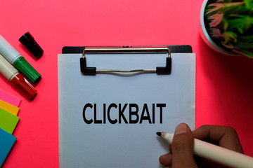 Clickbait write on sticky notes. Isolated on pink table background