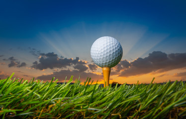 golf ball on tee pegs ready to play in the golf course at sunset with clouds in the evening day background, sport outdoor