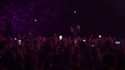 Close up people waving hands dance have fun in a live concert festival music performance celebration rock stage crowd event party disco light nightlife show slow motion