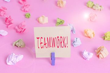 Writing note showing Teamwork. Business concept for combined action of group especially when effective and efficient Colored crumpled papers empty reminder pink floor background clothespin