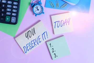 Text sign showing You Deserve It. Business photo showcasing should have it because of their qualities or actions Wire mouse portable calculator notepads paper sheets clips color background
