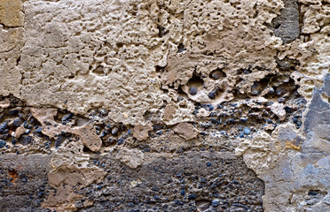 Beautiful old decaying wall with weathered layers of plaster, stone and brick.