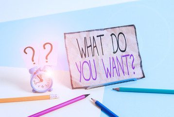 Writing note showing What Do You Want Question. Business concept for say or write in order to ask demonstrating about something Mini size alarm clock beside stationary on pastel backdrop