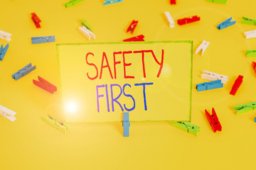 Word writing text Safety First. Business photo showcasing used to say that the most important thing is to be safe Colored clothespin papers empty reminder yellow floor background office