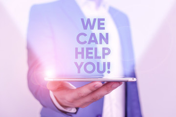 Writing note showing We Can Help You. Business concept for offering good assistance to customers or friends Man in the blue suite and white shirt holds mobile phone in the hand