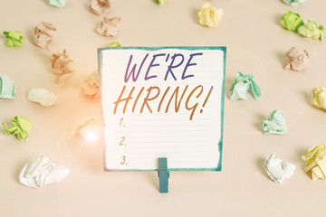 Handwriting text We Re Hiring. Conceptual photo recently employ someone or pay someone to do particular job Colored crumpled papers empty reminder pink floor background clothespin