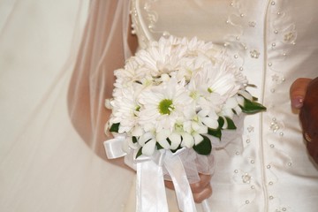 Bride's hand holding a white bouquet of chrysanthemums