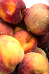 A bunch of health red and yellow peaches close up. A background of peaches