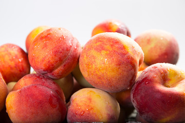 Front view of healthy red and yellow peaches on white background in a with copy area