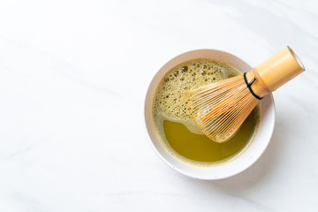 hot matcha green tea cup with green tea powder and whisk