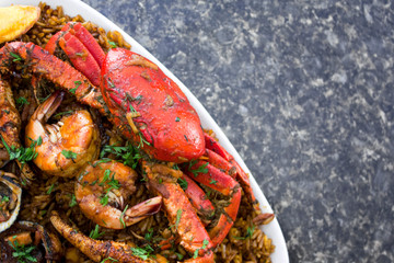 Corner view of crab with shrimps and rice in a black marble background. Delicious ecuadorian dish seaman rice.