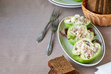 Raw apples stuffed with herring and eggs 