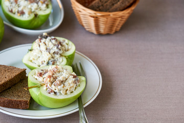 Raw apples stuffed with herring and eggs 