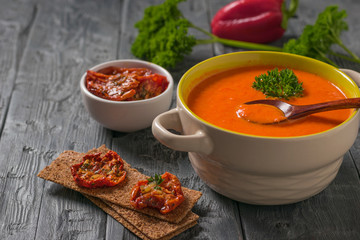 Wooden spoon in bowl with cream soup on wooden table.