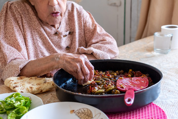 Old woman enjoying some homemade okra