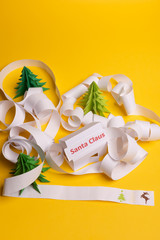 Long twisted expanded letter for Santa Claus. Copy space. yellow background. View from above.