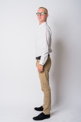 Full body shot profile view of young blonde businessman looking at camera