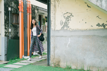 Obraz na płótnie Canvas copy space concept. full length young asian japanese woman traveler walking in path way on stone in back garden of little village. beauty female tourist relax and sightseeing small town in taiwan.