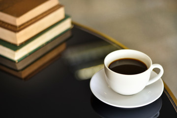 Black coffee in a white cup on a black glass table, Concept free time for thinking.