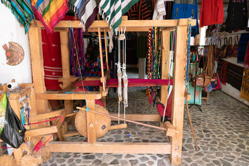 El telar de pie tiene hilo de algodón rojo, blanco y está listo para ser usado por la tejedora Maya en Guatemala.