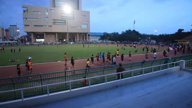 Time lapse of people running on running track .