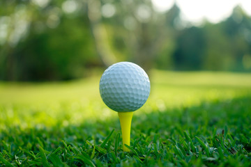 Golf ball on tee in beautiful golf course