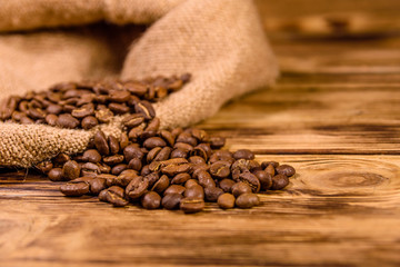 Sackcloth and scattered coffee beans on wooden table