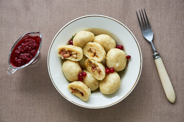 Potato dumplings with fried bacon, onions and lingonberry sauce 