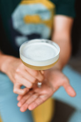 A sour cocktail in a beautiful glass in man's hands, selective focus lifestyle photo