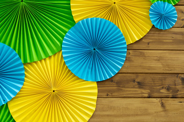 origami blue yellow and green colorful circles hand made decoration objects on wooden deck wall background texture empty copy space for your text 