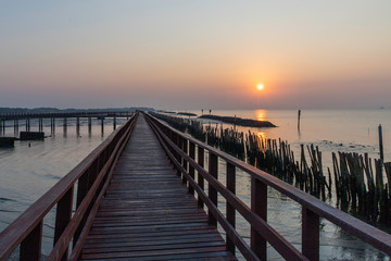 Fototapeta na wymiar Sunrise with red wooden bridge