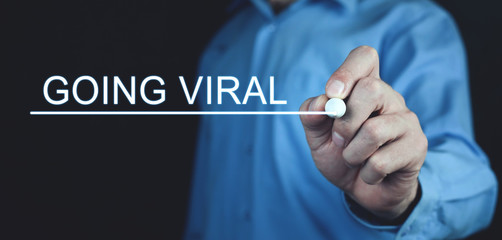 Businessman writes Going Viral text in screen.