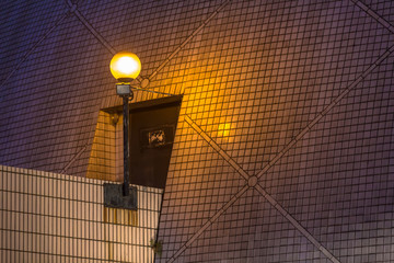 Mosiac style wall illuminated by street lighting in tungsten color