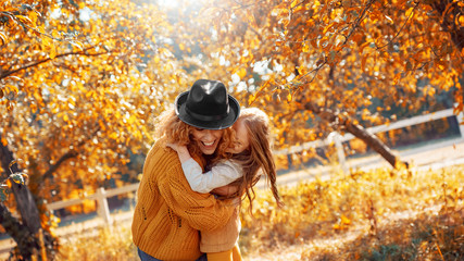 Young adult mother and daughter looking at carved pumpkin with smoke
